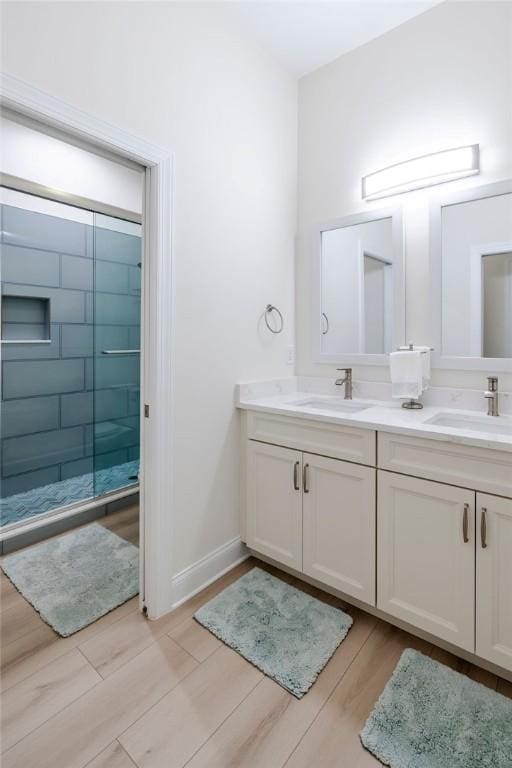 bathroom with vanity, wood-type flooring, and walk in shower