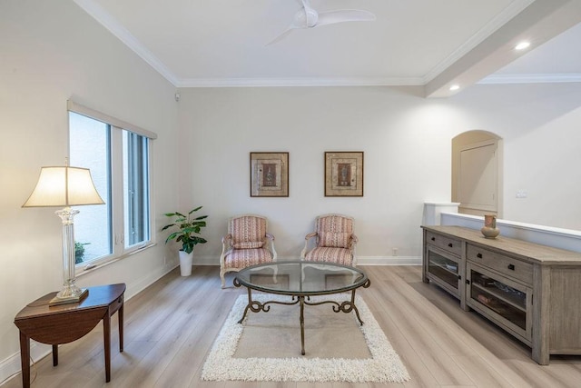 living area featuring ceiling fan, ornamental molding, and light wood-type flooring