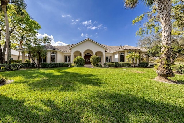 mediterranean / spanish house featuring a front lawn