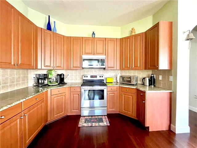 kitchen with tasteful backsplash, light stone counters, stainless steel appliances, and dark hardwood / wood-style floors