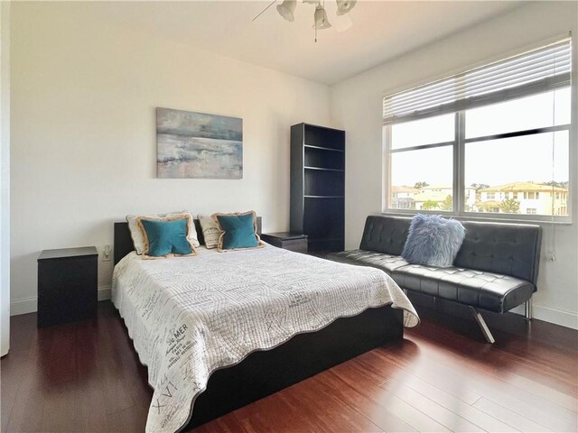 bedroom featuring ceiling fan, a raised ceiling, wood-type flooring, and a closet