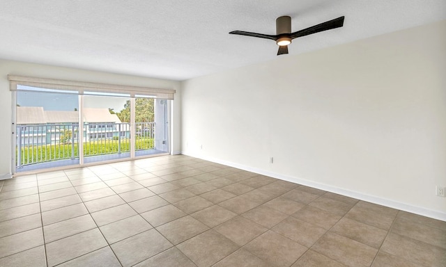 tiled empty room with a textured ceiling and ceiling fan