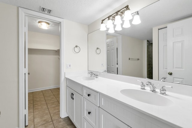 bathroom with vanity, tile patterned flooring, and a textured ceiling