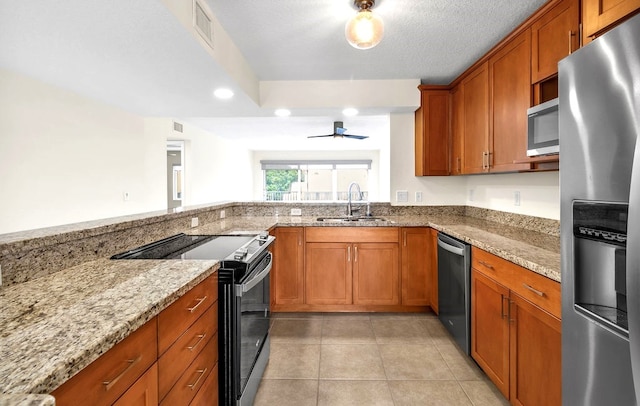 kitchen with light stone counters, sink, light tile patterned floors, ceiling fan, and appliances with stainless steel finishes