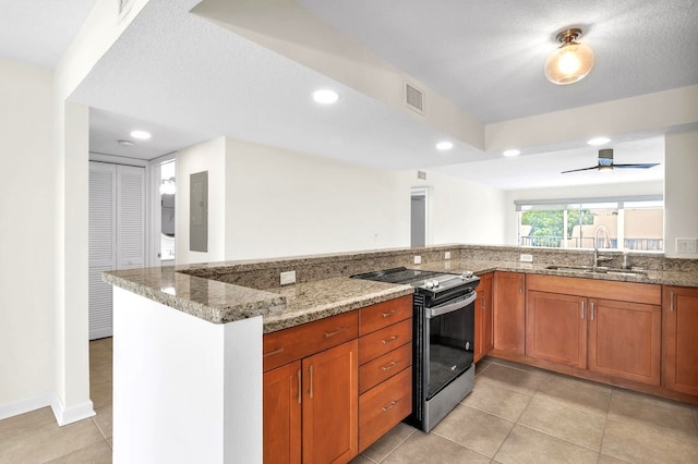 kitchen featuring kitchen peninsula, light stone countertops, stainless steel range with electric stovetop, and sink