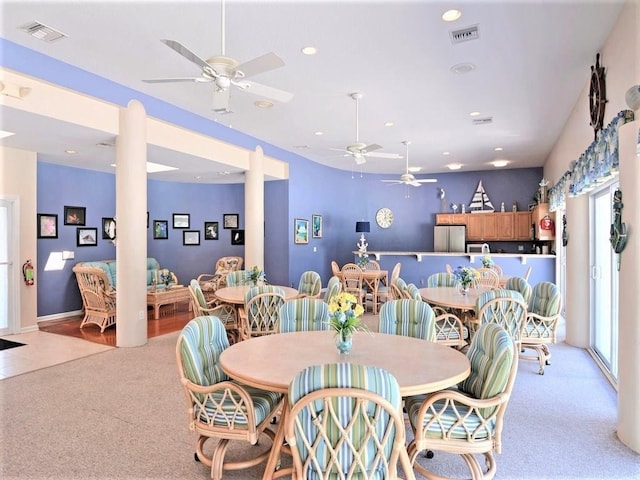 dining space with light carpet and ceiling fan