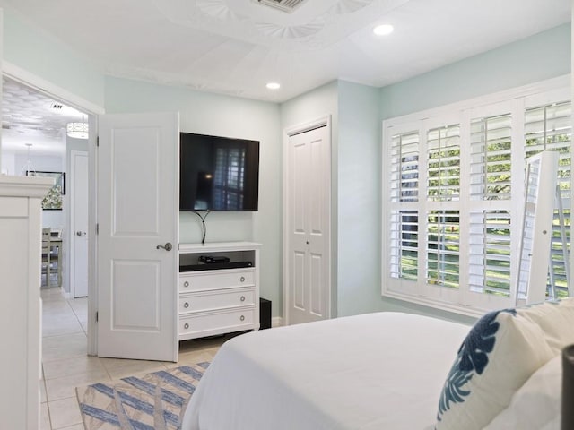 bedroom featuring light tile patterned floors, visible vents, a closet, and recessed lighting