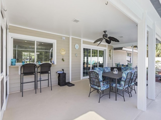 view of patio with a ceiling fan, outdoor dining space, and visible vents