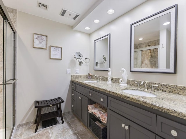 bathroom with double vanity, a stall shower, a sink, and visible vents