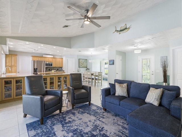 living area with lofted ceiling, recessed lighting, visible vents, a ceiling fan, and light tile patterned flooring