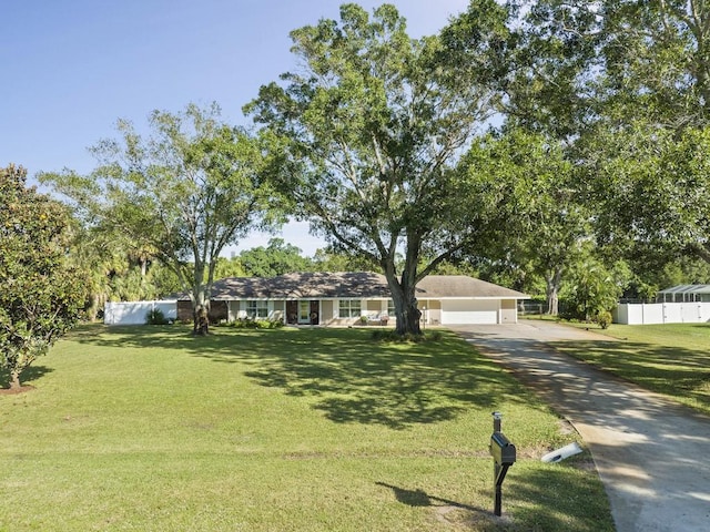 ranch-style house featuring a front yard, fence, and an attached garage