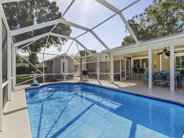 view of pool featuring a fenced in pool, a ceiling fan, a lanai, an outdoor structure, and a patio area