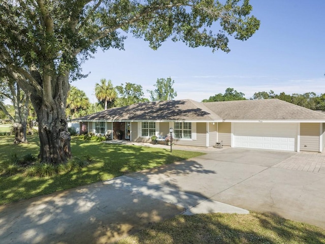 ranch-style house featuring driveway, a front lawn, and an attached garage