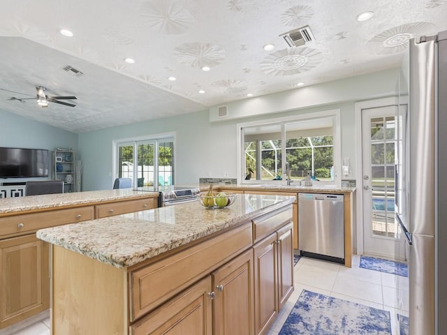 kitchen featuring light tile patterned floors, appliances with stainless steel finishes, a kitchen island, and visible vents