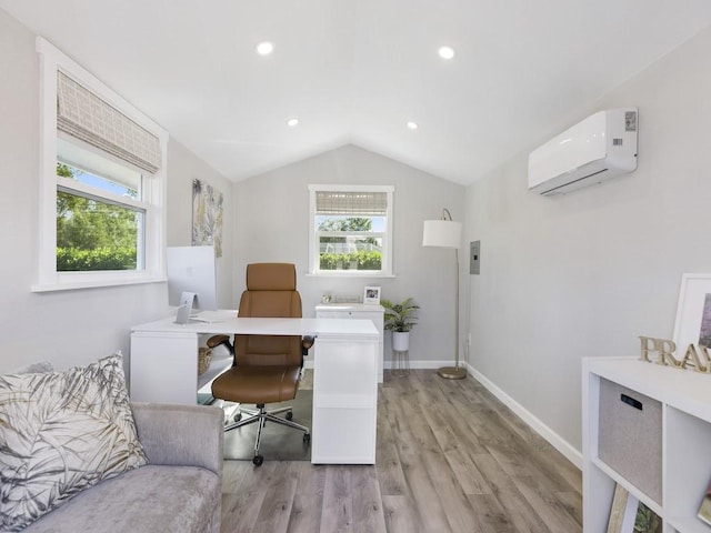 office area featuring light wood-style flooring, vaulted ceiling, a wealth of natural light, and a wall mounted AC