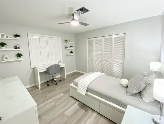 bedroom featuring a closet, visible vents, light wood-style flooring, ceiling fan, and baseboards