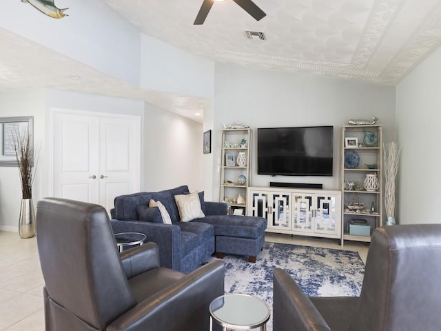 living room with light tile patterned floors, ceiling fan, visible vents, baseboards, and vaulted ceiling