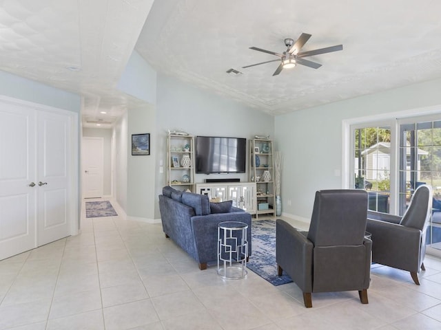 living area with light tile patterned floors, baseboards, visible vents, and vaulted ceiling