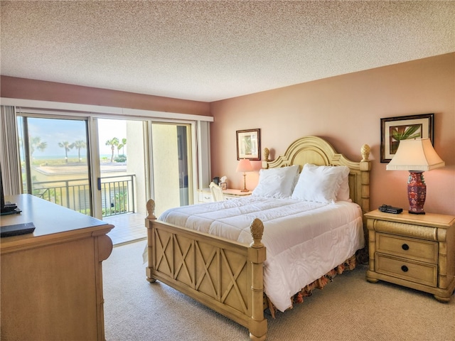 bedroom with access to exterior, a textured ceiling, and light colored carpet