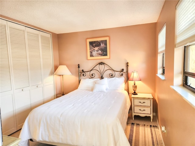 bedroom with a textured ceiling and a closet