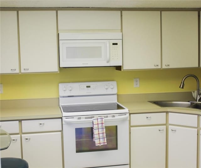 3939 Ocean Dr Unit 205C, Vero Beach, FL 32963 - kitchen featuring white appliances, a sink, light countertops, and white cabinets