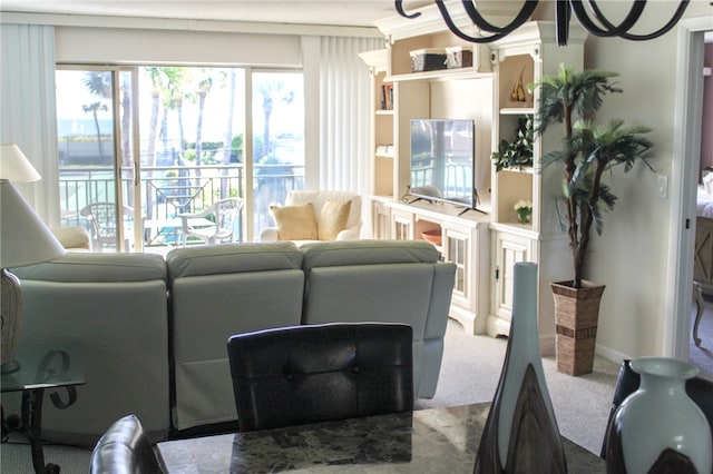 carpeted living room with a chandelier