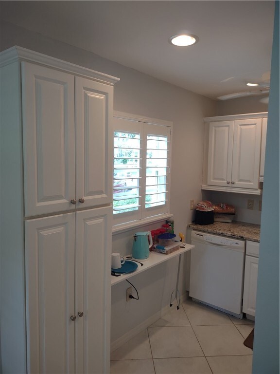 kitchen with dishwasher, white cabinetry, and light tile patterned floors