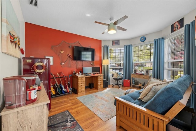 living room featuring light hardwood / wood-style floors and ceiling fan