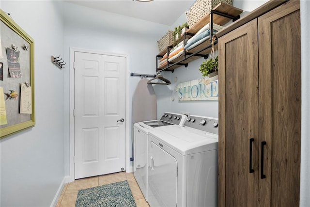 laundry area featuring light tile patterned floors and washer and clothes dryer