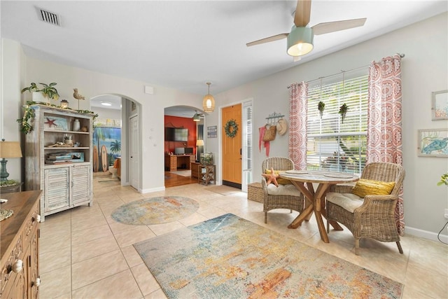 tiled dining space featuring ceiling fan