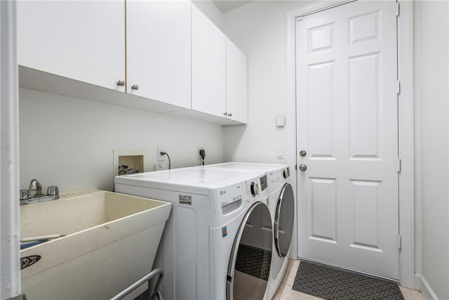 clothes washing area with cabinets, light tile patterned flooring, sink, and independent washer and dryer