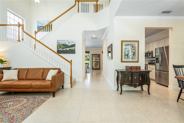 foyer with light tile patterned floors and crown molding