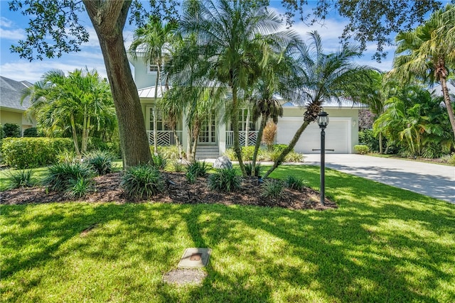 view of front of property with a garage and a front lawn