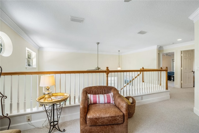 sitting room with light colored carpet, a textured ceiling, and ornamental molding