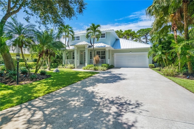 view of front of property featuring a garage, a front lawn, and covered porch