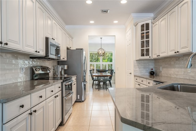 kitchen with white cabinetry, sink, light tile patterned floors, and stainless steel appliances