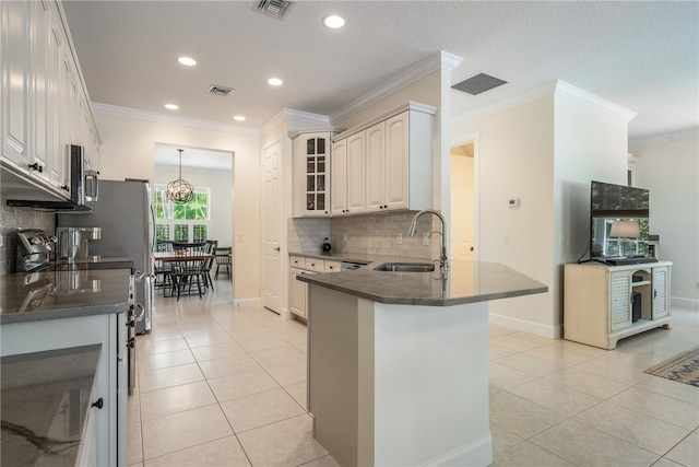 kitchen with kitchen peninsula, sink, crown molding, and light tile patterned flooring