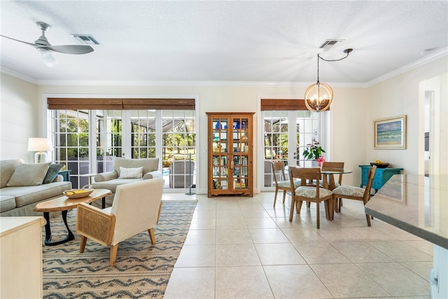 living room featuring french doors, ceiling fan with notable chandelier, light tile patterned floors, and crown molding