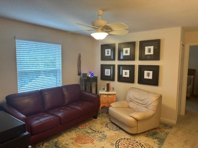 living room with ceiling fan and carpet floors