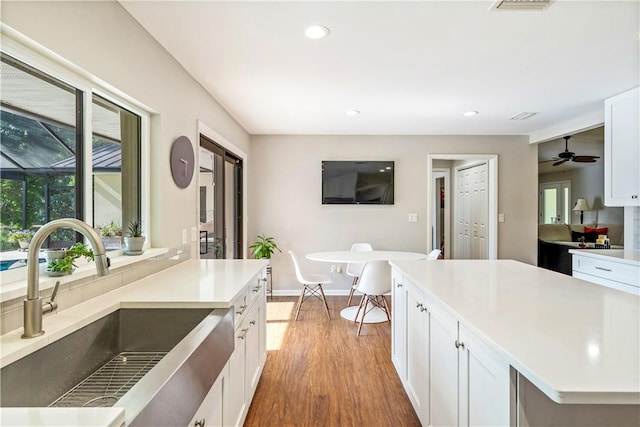 240 44th Ter SW, Vero Beach, FL 32968 - kitchen featuring a sink, wood finished floors, white cabinets, and recessed lighting