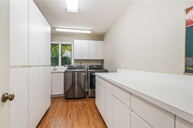 240 44th Ter SW, Vero Beach, FL 32968 - washroom featuring cabinet space, washer and dryer, and wood finished floors
