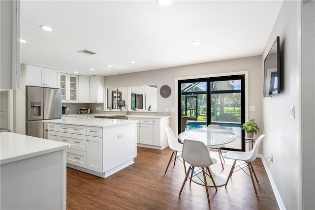 240 44th Ter SW, Vero Beach, FL 32968 - kitchen featuring stainless steel refrigerator with ice dispenser, glass insert cabinets, dark wood-style flooring, light countertops, and recessed lighting