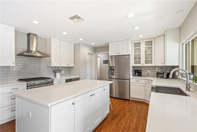 240 44th Ter SW, Vero Beach, FL 32968 - kitchen featuring appliances with stainless steel finishes, wall chimney exhaust hood, a sink, a center island, and backsplash