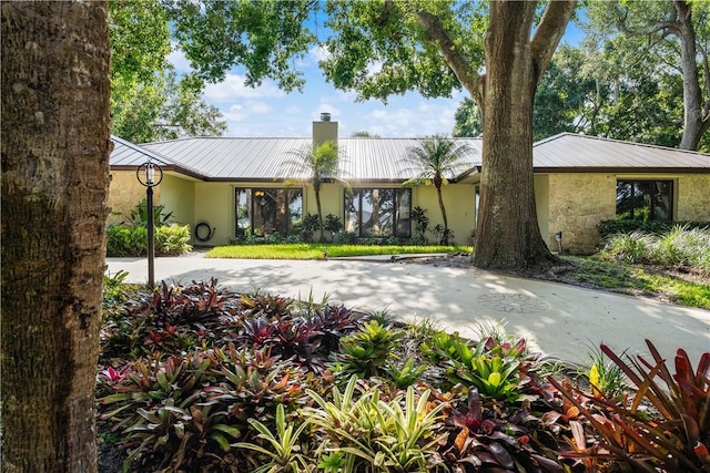 240 44th Ter SW, Vero Beach, FL 32968 - view of front of property featuring metal roof, a chimney, and stucco siding