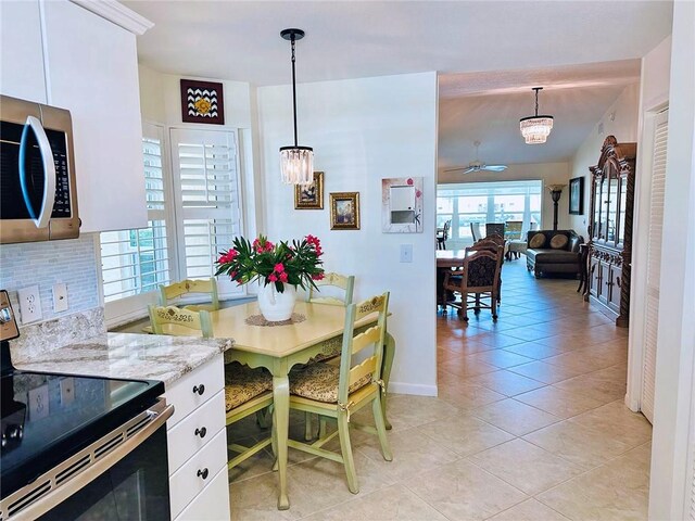 600 E Lake Jasmine Cir Unit 206, Vero Beach, FL 32962 - dining space featuring a chandelier, light tile patterned floors, baseboards, and ceiling fan