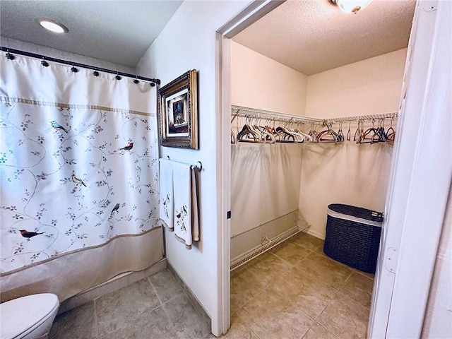600 E Lake Jasmine Cir Unit 206, Vero Beach, FL 32962 - full bath featuring toilet, tile patterned flooring, a shower with curtain, and a textured ceiling