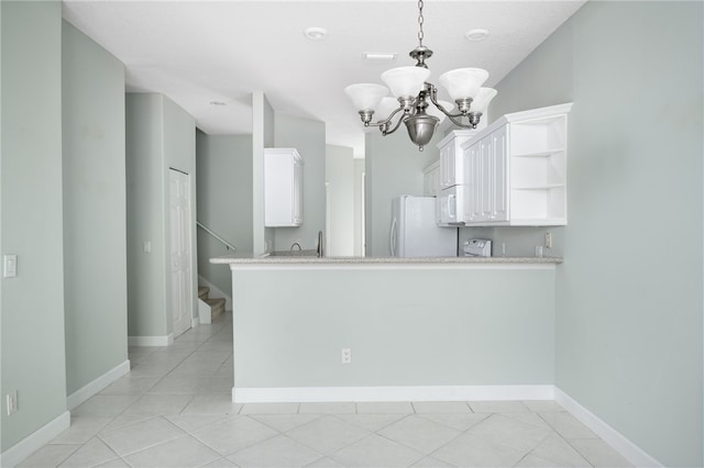 kitchen with white cabinets, decorative light fixtures, white appliances, and kitchen peninsula