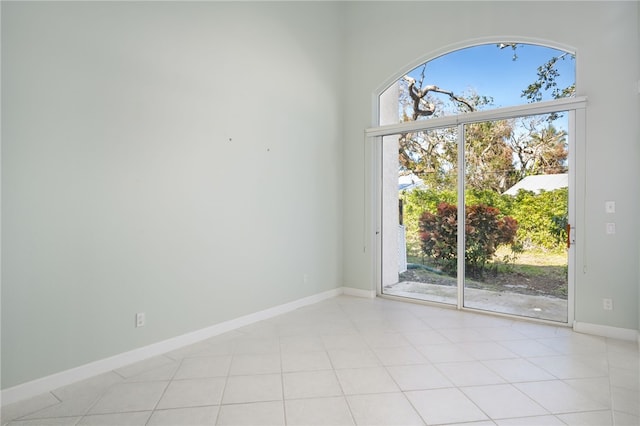 empty room featuring light tile patterned floors and a healthy amount of sunlight