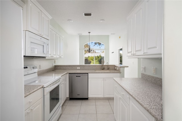 kitchen featuring white appliances, white cabinetry, a notable chandelier, and sink