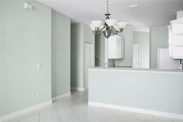 empty room featuring sink, light tile patterned flooring, and a chandelier